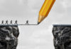 Conquering the Changing Business Climate Drawing A Bridge And Conquering Adversity Business Concept As A Group Of People Running From One Cliff To Another With The Help Of A Pencil Line Sketc